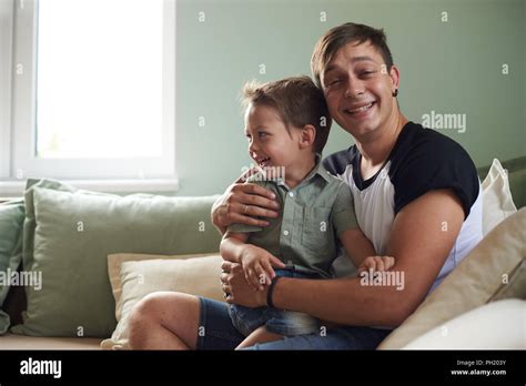 Happy Father With His One Year Old Son Playing At Home On The Bed Stock