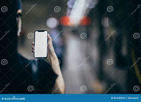 Back View Of A Female Hand Holding A Cell Phone With An Illuminated