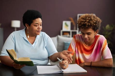Confident Mature Female Tutor Explaining Something To Teenage Boy Stock Photo Image Of Mother