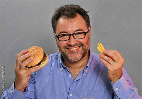 Hombre Gordo Feliz Comiendo Hamburguesa Y Patatas Fritas Stock Photo