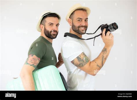 Jeune gay couple de deux hommes tenant une valise en vacances d été sur fond blanc Photo Stock