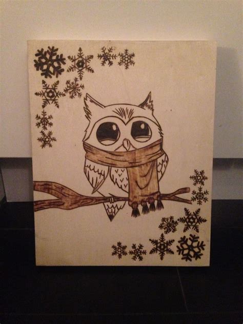 an owl is sitting on a branch with snowflakes