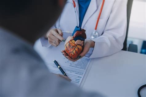 Médico explicando o coração a um paciente idoso Médico explicado o