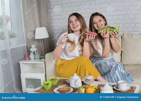 Deux Jeunes Filles Sasseyent Sur Le Divan Image Stock Image Du Fille