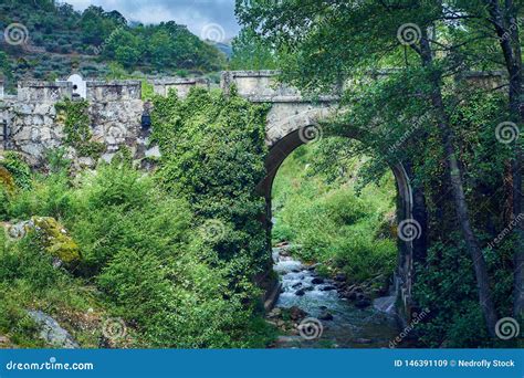 Puente Viejo De La Roca Que Cruza Una Corriente En El Medio De La