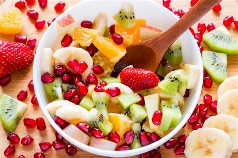 Fruta Picada Con Una Cuchara De Madera En Un Plato Blanco De Madera