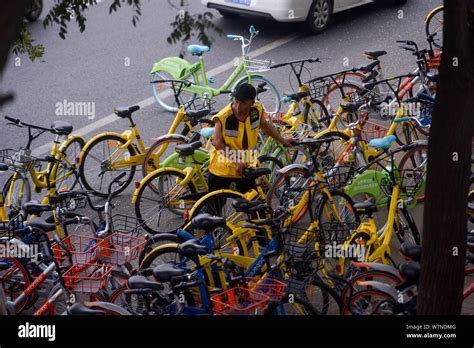 A Chinese Worker From Bike Sharing Company Ofo Lines Up Bicycles Along