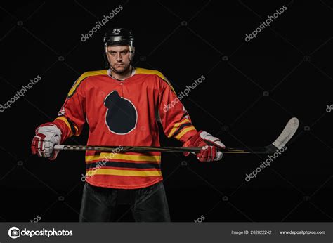 Professional Ice Hockey Player Holding Hockey Stick Looking Camera