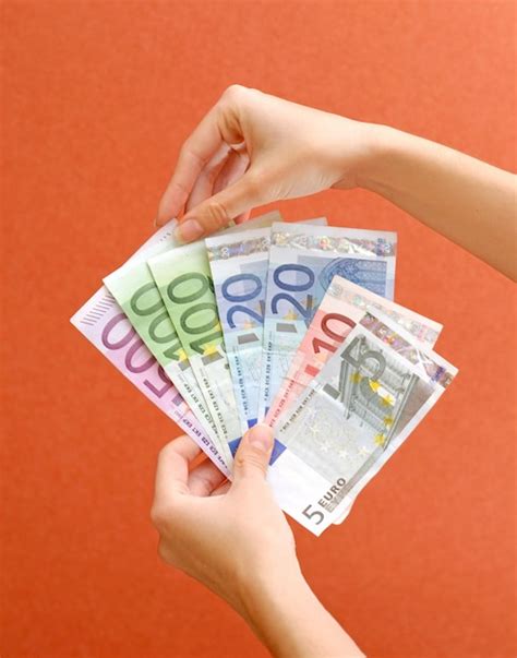 Premium Photo A Person Holding A Stack Of Euro Banknotes In Their Hands