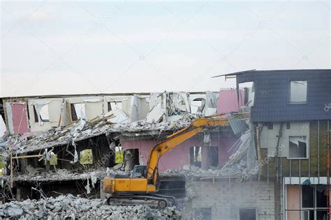 Una Excavadora Amarilla Derriba Un Edificio De Varios Pisos Con Un