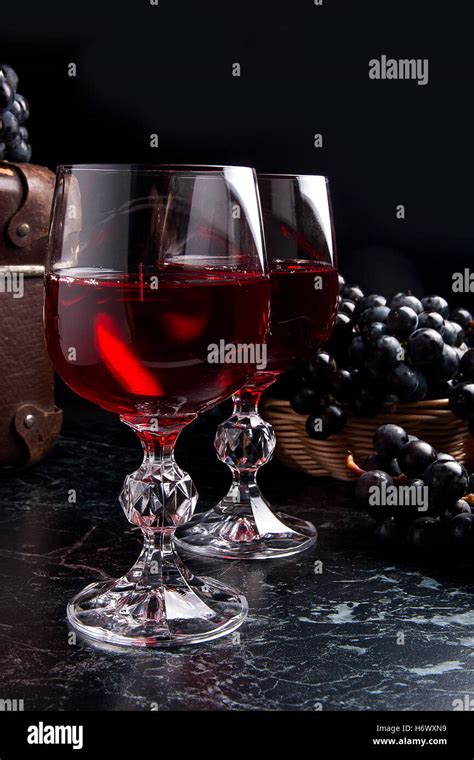 2 vaso de vino tinto en mármol oscuro fondo Uvas azules sobre fondo de