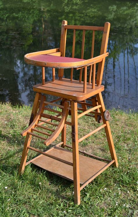 Ancienne chaise haute de bébé en bois La tablette se relève pour