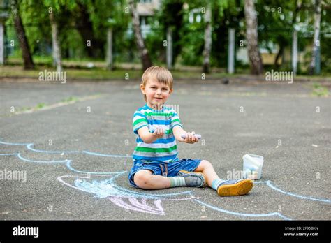 Lindo Niño Y Niña Dibujando Con Tiza En La Acera En El Parque