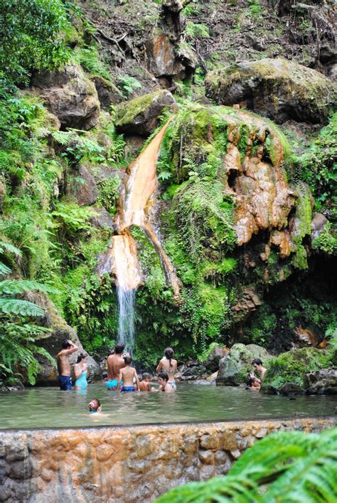 Some People Are Standing In The Water Near A Waterfall