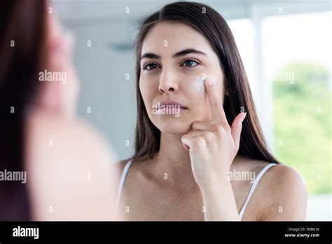 Brunette Applying Face Cream Stock Photo Alamy