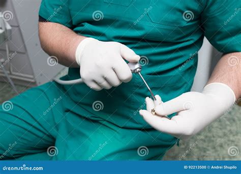 A Dentist Prepares An Implant In The Clinic Stock Photo Image Of