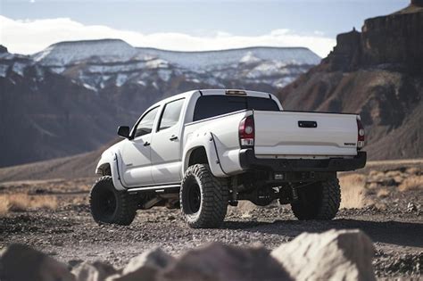 A White Pickup Truck Parked On A Dirt Road Premium Ai Generated Image