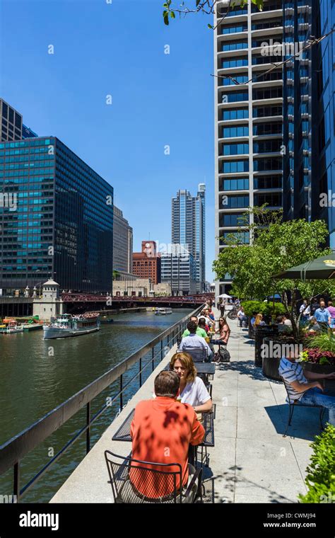 Restaurant terrace overlooking Chicago River with Monroe Street Bridge behind and tour boat on ...