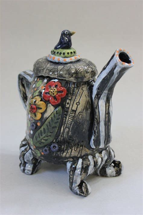 A Ceramic Teapot With Flowers Painted On It