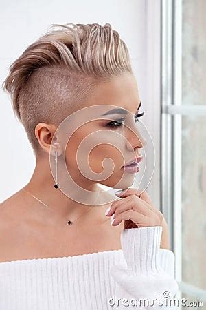 Closeup Blonde Model With Bright Make Up Bare Shoulders And Short Hair With Shaved Temples In