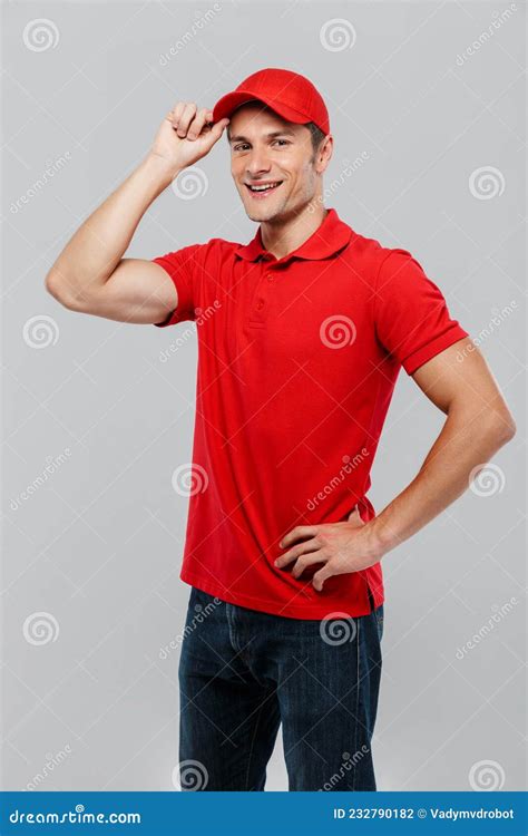 Young Delivery Man Wearing Red Hat Smiling And Looking At Camera Stock