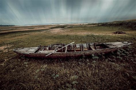 Premium Photo Abandoned Boat Moored On Land Against Sky