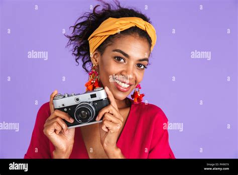 Picture Of Cheerful African Woman In Dress Having Fun With Retro Camera