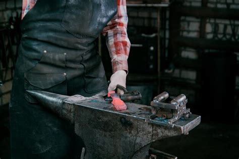 Premium Photo Blacksmith Working With Red Hot Metal Workpiece Of New Hammer At Anvil In A Forge