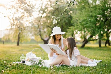 Mãe e filha no jardim da primavera em um xadrez folheiam e folheiam um