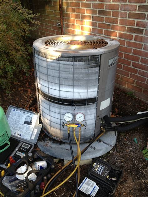 An Air Conditioner Sitting On Top Of A Pile Of Junk Next To A Brick Wall