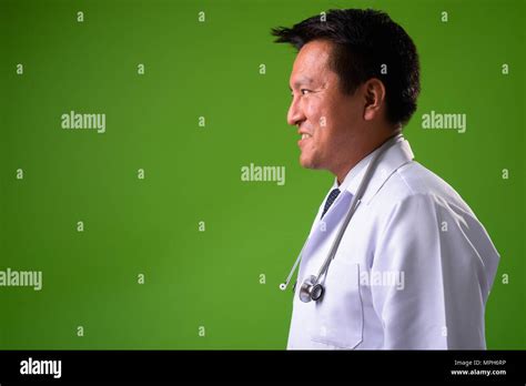 Mature Japanese Man Doctor Against Green Background Stock Photo Alamy