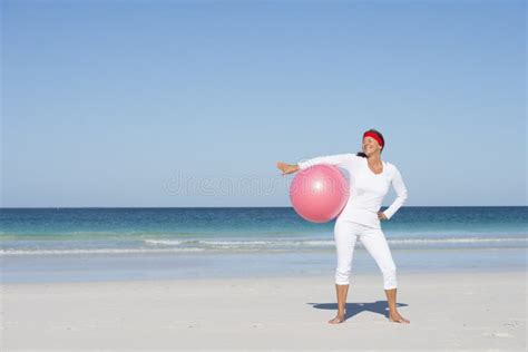 Mujer Madura Del Ajuste Deportivo Que Ejercita La Playa Foto De Archivo