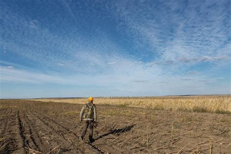 Mature Man Hunter With Gun While Walking On Field Premium Photo