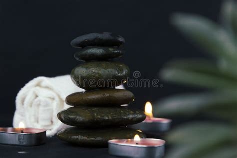 Black Hot Stones On Dark Wooden Background Layers Of Hot Stones Massage Setting Lit By Candles