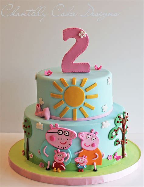 a two tiered cake with pep the pig and sun on top is decorated in ...