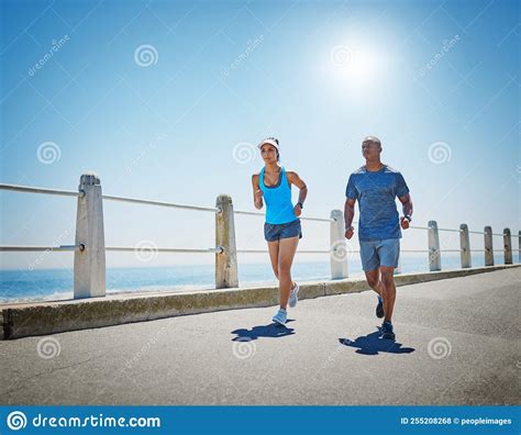 Persevering Together A Young Sporty Couple Out For A Run Together