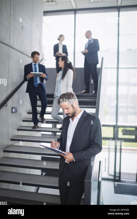 Businessman Writing On Clipboard Stock Photo Alamy