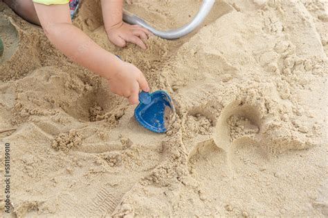 child digging hole in clean beach sand during sunny day with family ...