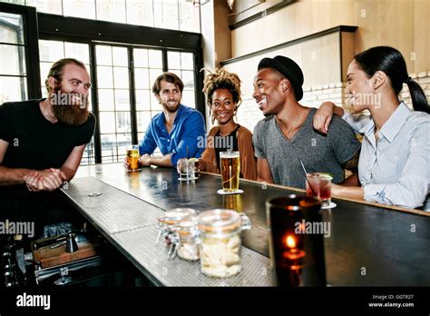 Smiling Bartender And Customers At Bar Stock Photo Alamy