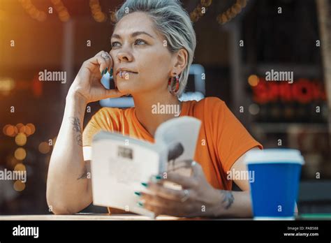 Attraktive blonde Mädchen mit Buch und trinken Kaffee im Cafe Stockfotografie Alamy