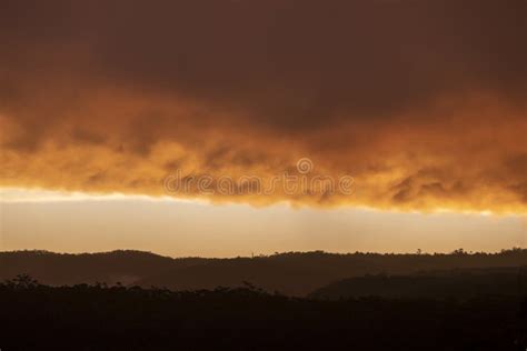 Photograph Of A Bright Orange Sunset Sky Over A Valley Stock Photo