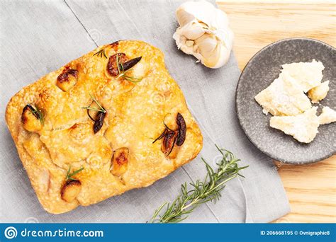 Italian Focaccia With Confit Garlic Cloves And Rosemary Alongside A