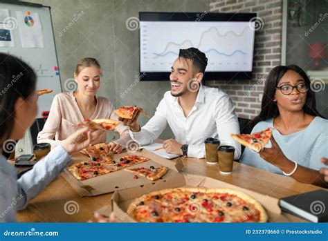 Diverse Multiethnic Colleagues Eating Pizza During Lunch Break In