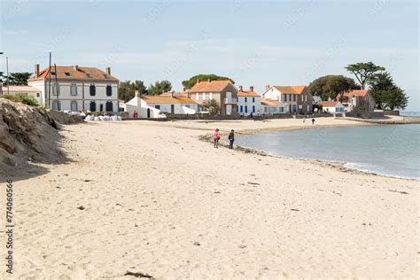 Plage de sable blond devant un village de pêcheurs montrant une érosion