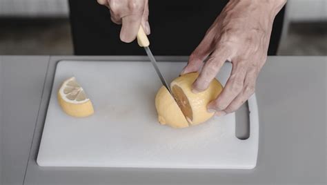 Premium Photo Hand Slicing Lemon With Knife