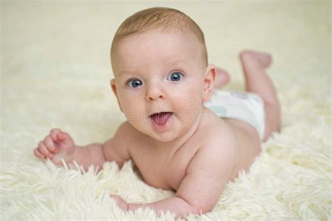 Baby Lying Down On A Soft Cozy Blanket And Looking At Camera Portrait