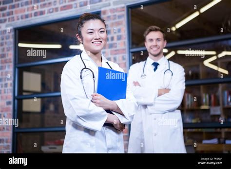 Smiling Doctors Standing With Arms Crossed Stock Photo Alamy