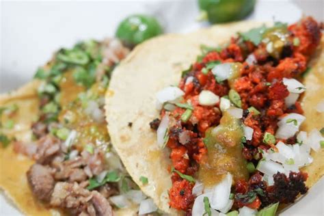 Two Tacos On A Plate With Toppings