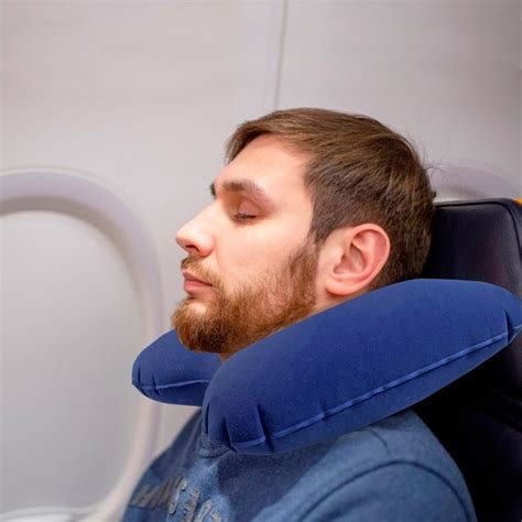 A Man Sitting In An Airplane Seat With His Head Resting On The Armrests