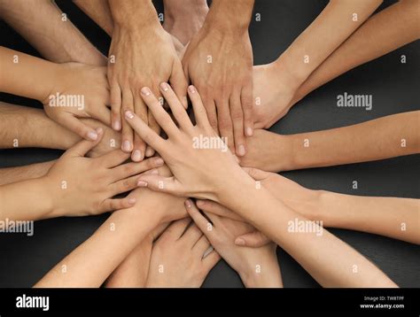 Group Of People Putting Hands Together As Symbol Of Unity Stock Photo